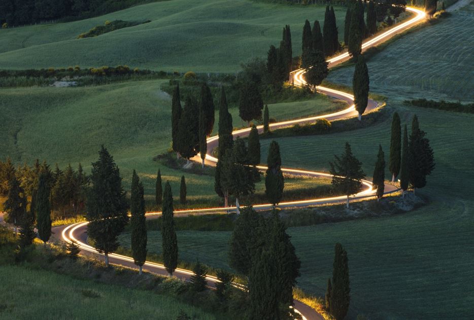 Winding road through the Tuscan countryside at dusk representing immigration opportunities to Italy and the European Union for residents of Dubai and the UAE