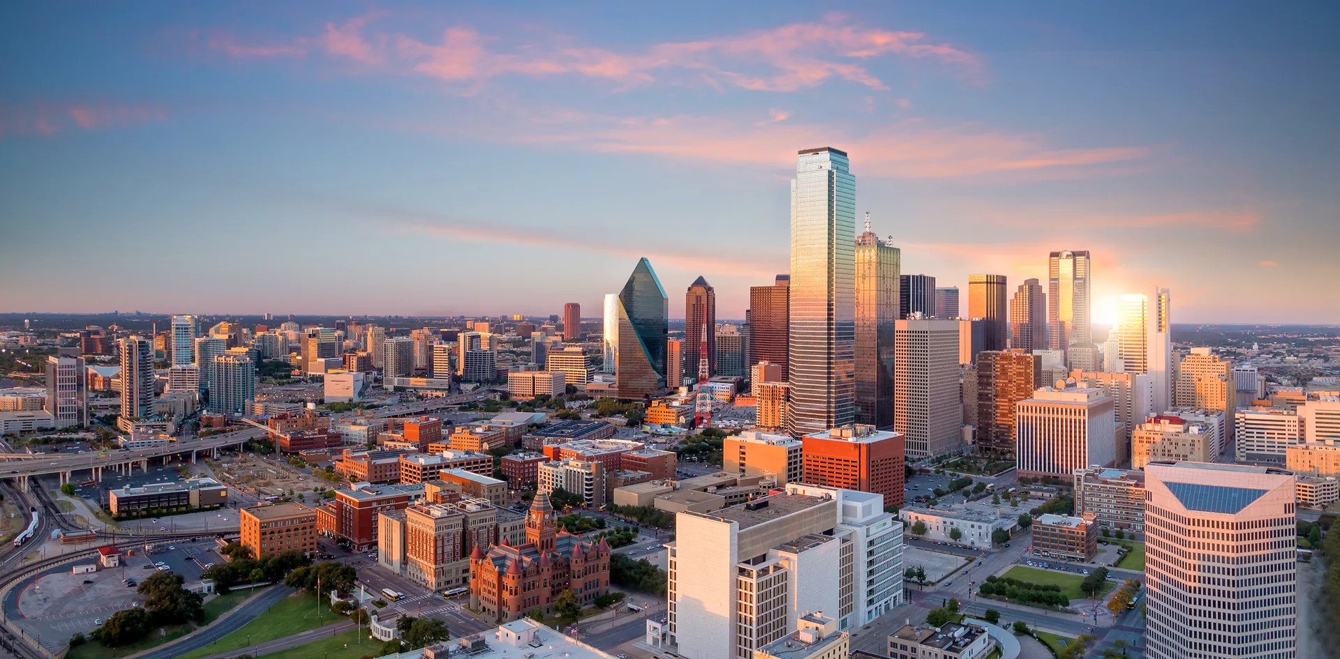 Aerial view of downtown Dallas, Texas skyline at sunset with Bank of America Plaza, Fountain Place, and the Old Red Museum visible &mdash; Davies &amp; Associates Dallas investor visa guide for foreign founders